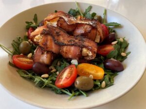 Schafskäse im Speckmantel auf Rucola